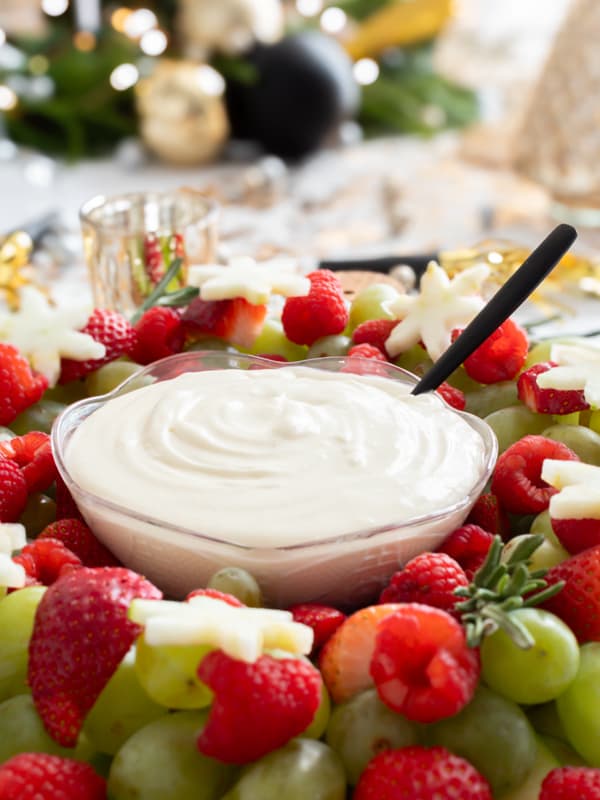 Creamy fruit dip with strawberries grapes and dip.