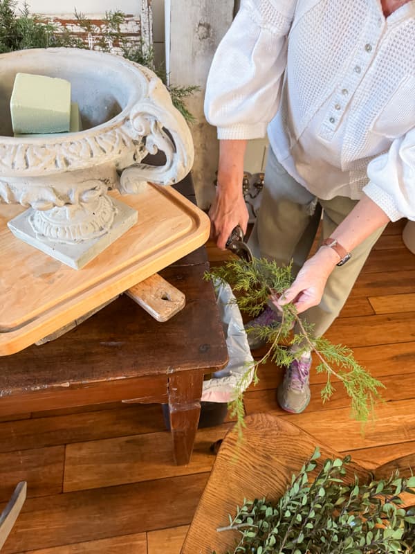 Cut fresh cedar stems and remove the lower stems before adding to arrangement.