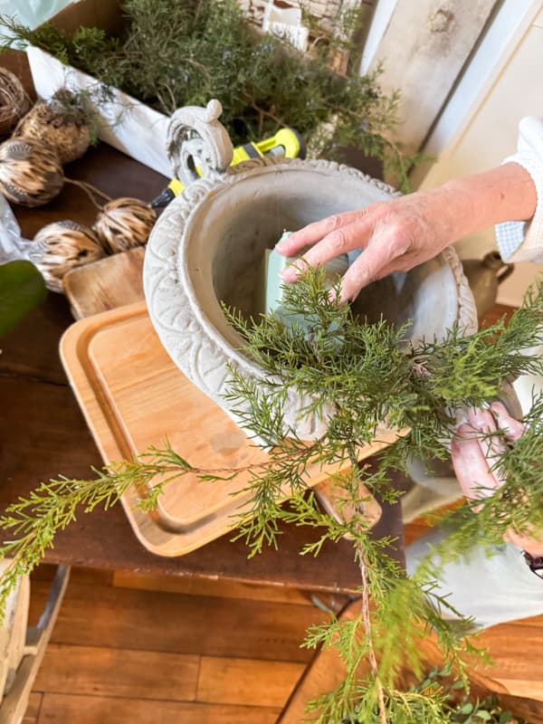 Add styrofoam to the bottom of a container to make a floral arrangement with real cedar stems.
