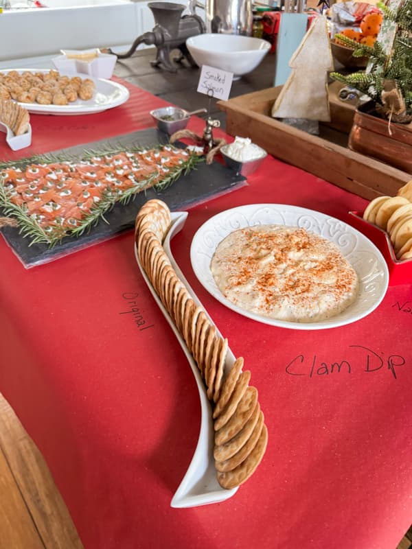 Clam dip and cracker on red craft paper for a Christmas Appetizer and Charcuterie party Idea.  