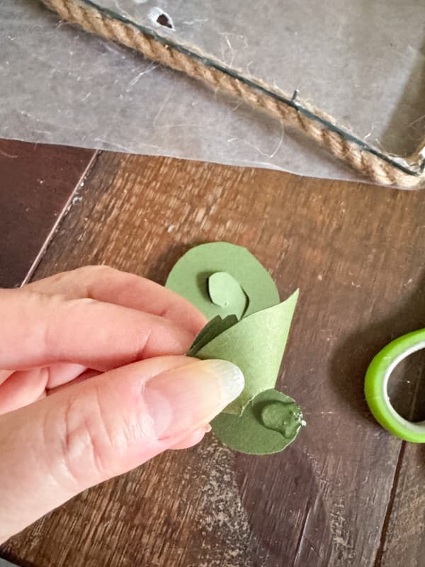 Add hot glue to hold the DIY spiral flower together for Valentine Wreath
