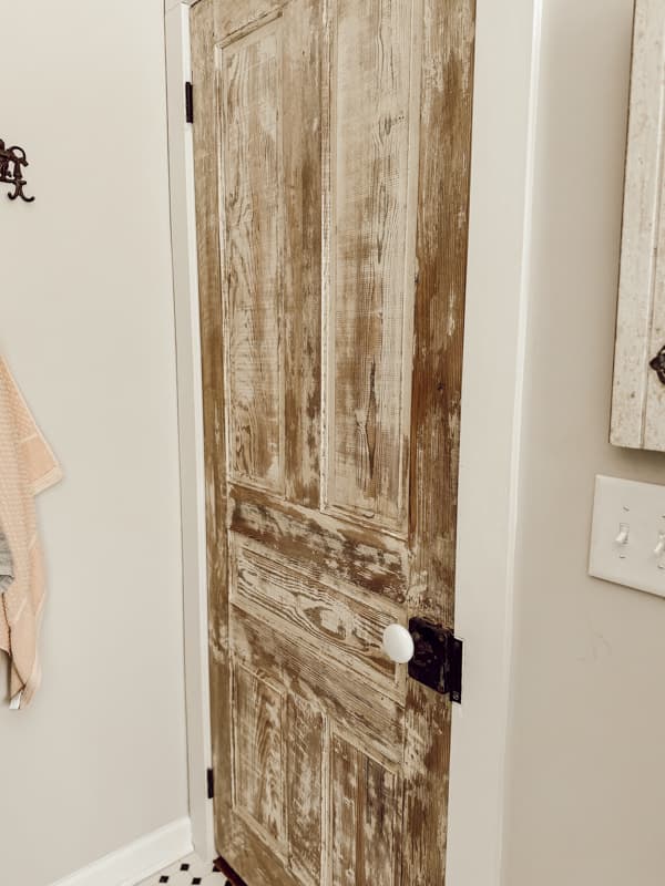 Painted Vintage wood Door in bathroom with original antique door hardware.  