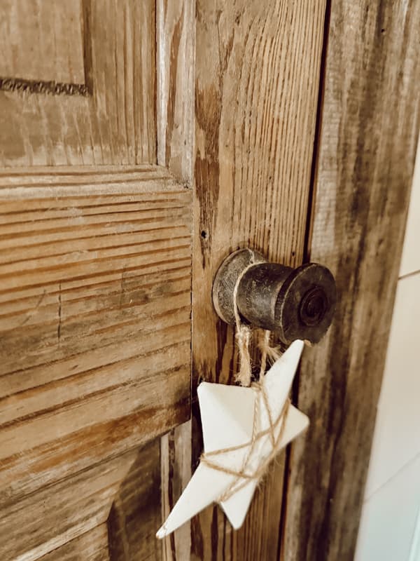Old wooden spool used as an old door knob on antique door in loft.  