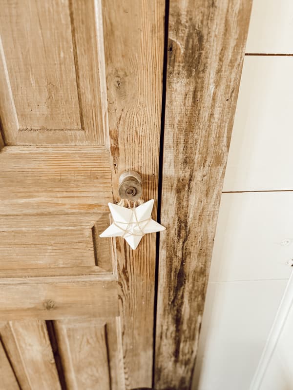 Old wooden spool used as an old door knob on antique door in loft. 