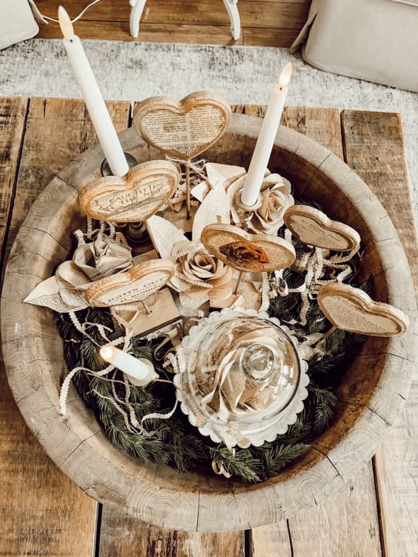 Wooden bowl coffee table centerpiece with heart stands, old book page paper roses and glass cloche