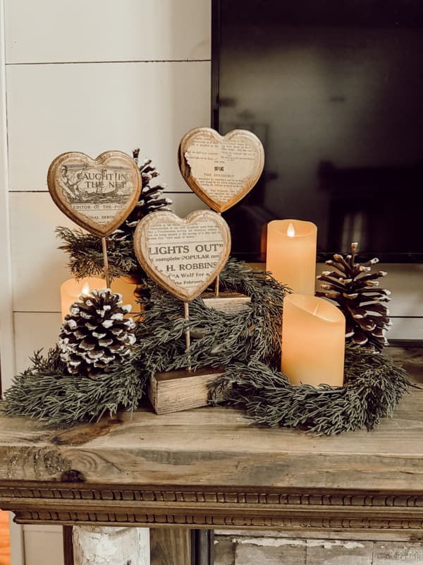 Rustic Heart Decorations on DIY Mantel with faux cedar candlerings, gathered pinecones, and flicker candles.  