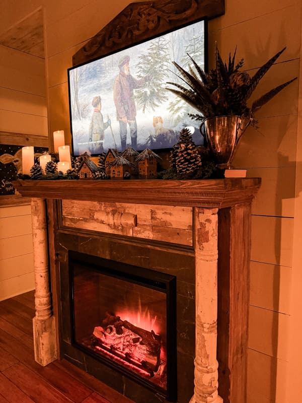 Cozy Hygge-inspired Winter Fireplace Mantel Decor.  Candles, pinecones, pheasant feathers on a shabby chic mantel. 