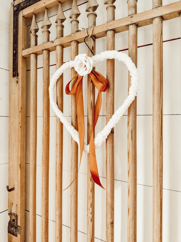 Shepa fleece wrapped Dollar Tree Heart Frame with DIY single paper rose and ribbon for Valentine's Day on Barn Door.