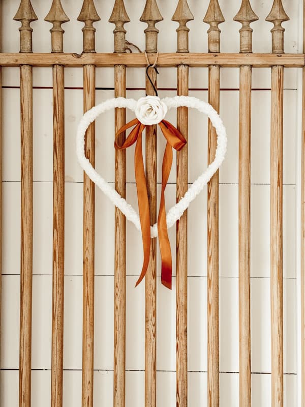 Shepa fleece wrapped Dollar Tree Heart Frame with single paper rose and ribbon for Valentine's Day on Barn Door.