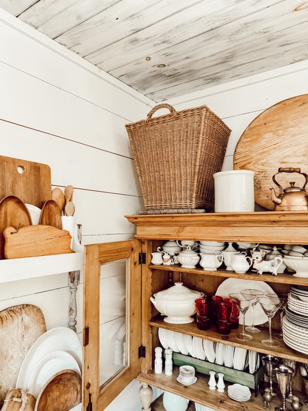 French Antique Basket for styling vintage cupboard top filled with ironstone and breadboards.