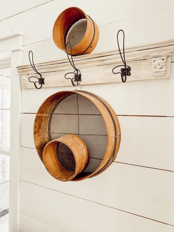 Decorating Vintage with old wooden sifters hanging on a pegboard rack. 