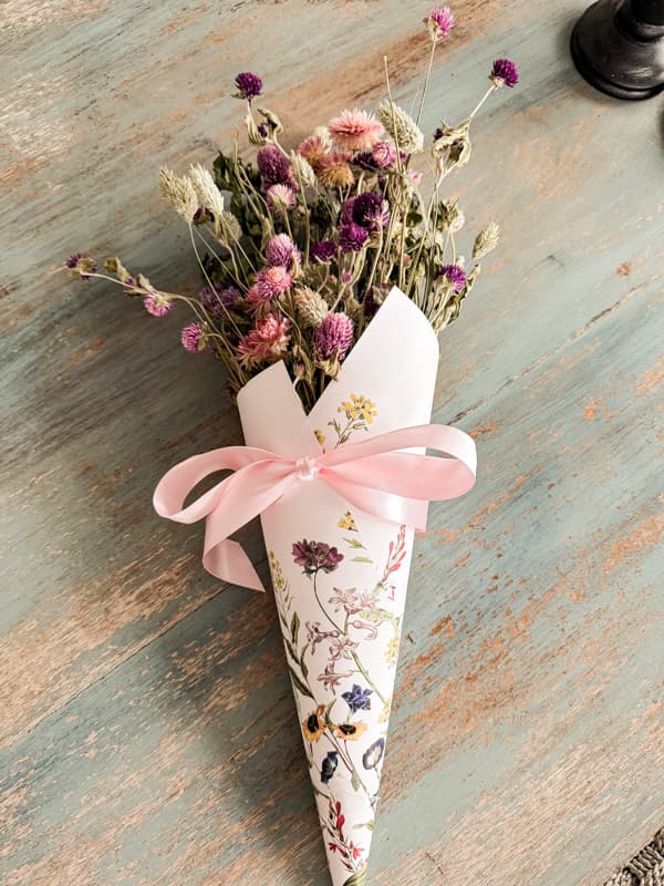  Dried flower cone pocket for DIY Valentine's gift with decorative paper and pink ribbon for a handcrafted gift idea.