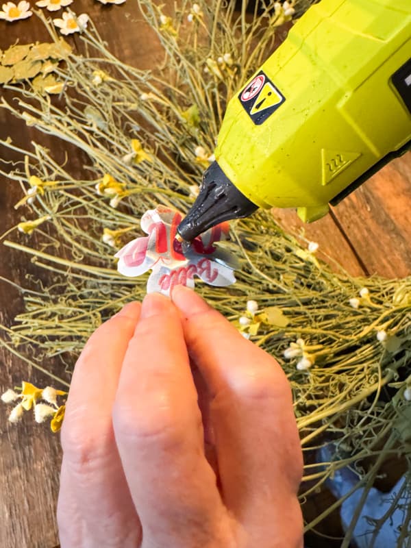 Add hot glue to upcycled aluminum can flower 