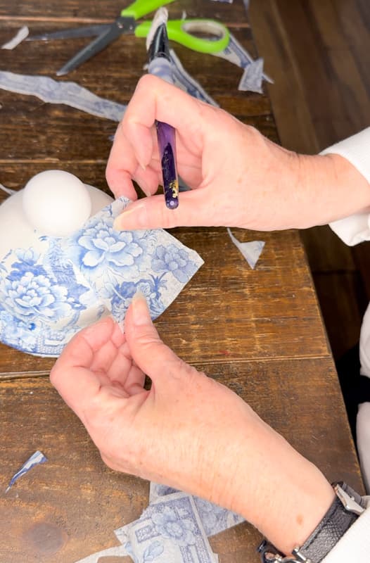 Cut pieces of the napkin to cover the blue and white ginger jar vase lid.