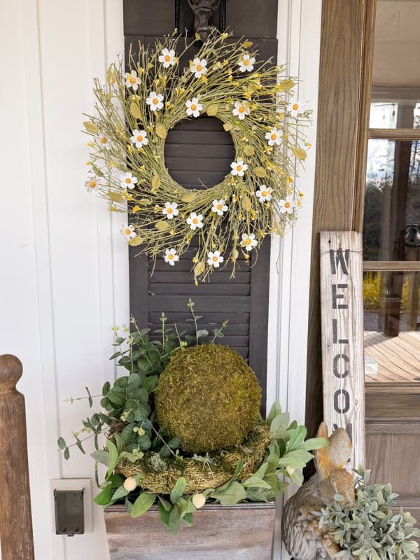 Planters with moss balls and greenery with DIY door shutters and DIY Metal Flower Wreath for Spring Front Porch Decor. 