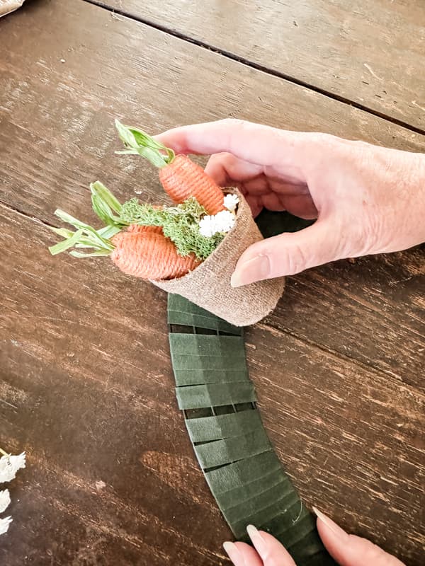 Attached seed pots filled with carrots, greenery and flowers to Dollar Tree Easter Wreath Frame.