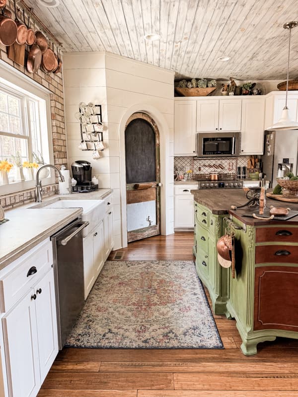 Farmhouse Kitchen with green DIY repurposed furniture island and farmhouse sink.  Decorate Above kitchen Cabinets.