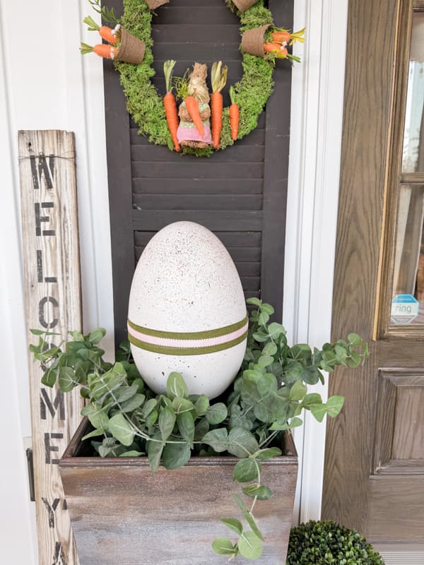 Porch planter filled with DIY Speckled Easter Egg using Dollar Tree crafts.  bunny and carrot wreath for front porch Easter Decorations
