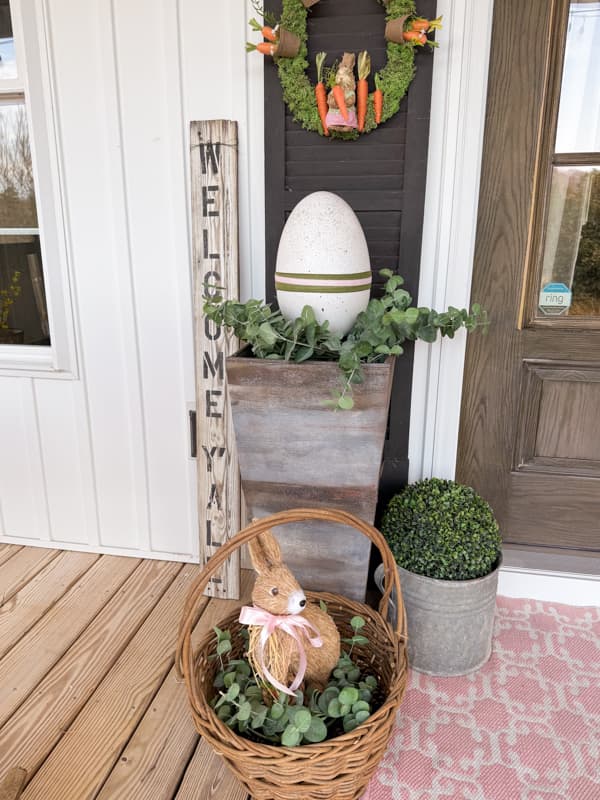 Porch planter filled with DIY Speckled Easter Egg using Dollar Tree crafts.  bunny and carrot wreath for front porch Easter Decorations