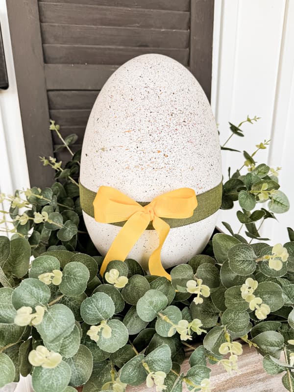 Dollar Tree Large Easter Egg with green and yellow bow in DIY porch planter for Easter Egg Decorations.  