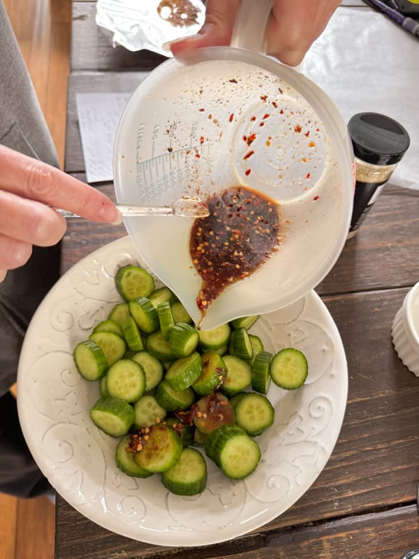Pour spicy Chinese Pickled Cucumber marinade over cucumbers