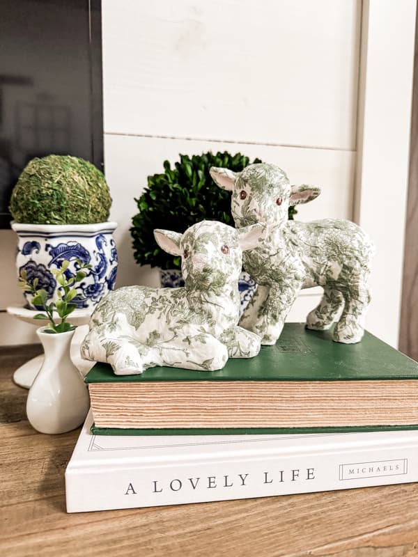 Easter Lamb Decoratons - Green and white lambs on mantel with topiaries and books