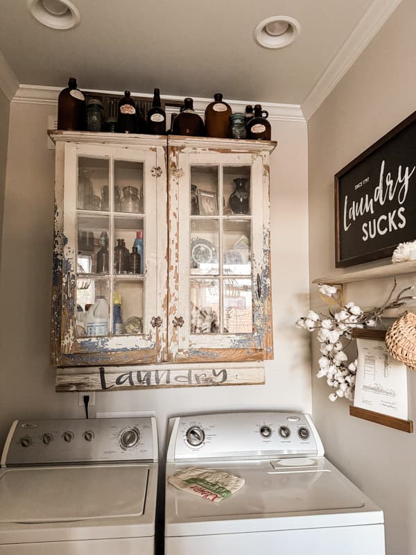 Chippy painted wall cabinet above washer and dryer.  