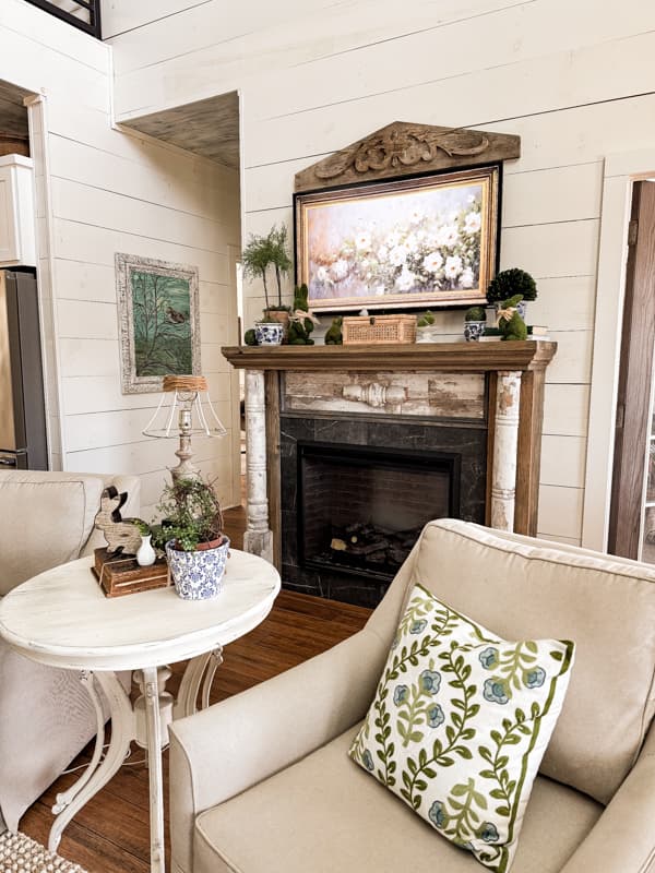 Vintage salvaged pediment over TV with shabby chic faux fireplace mantel.  