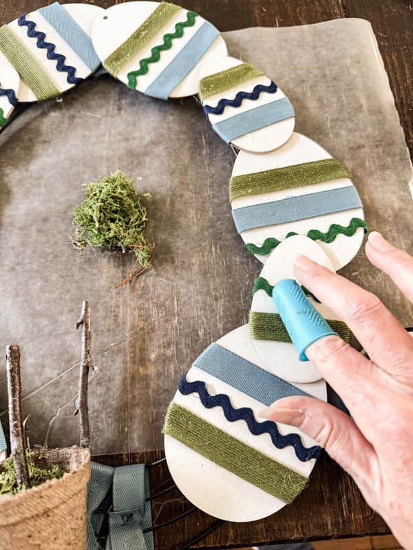 Attached wooden Easter Eggs to The DIY Easter Wreath with hot glue.