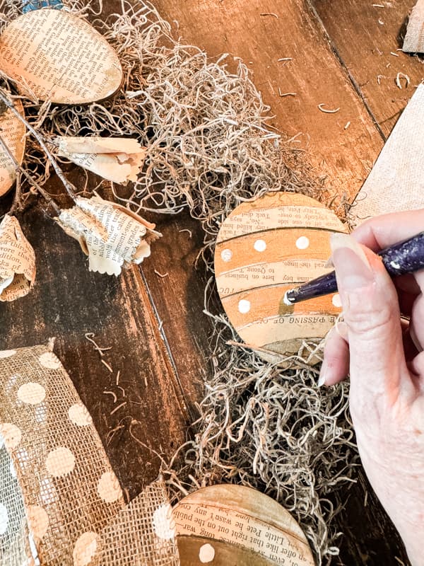 Paint white dots on DIY old book page Wooden Easter Eggs.