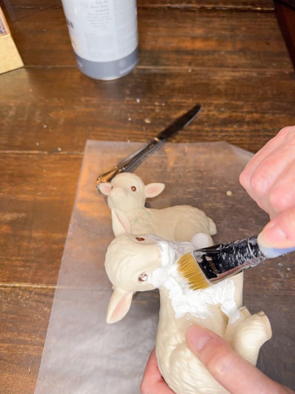Paint thrift store inexpensive lambs with white paint for napkin decoupage transformation.