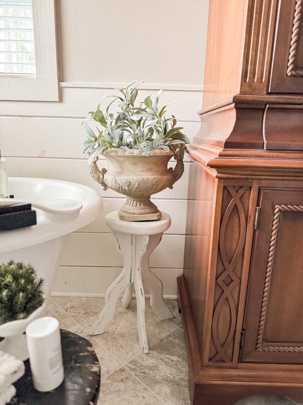 thrifted plant stand with urn filled with artifical lamb ears.  