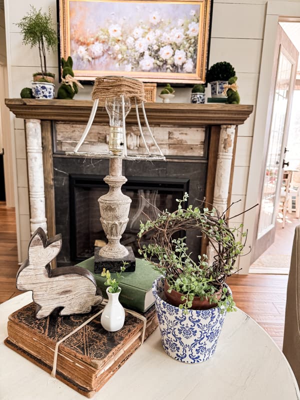 blue and white napkin decoupage clay pot with DIY grapevine topiary and bunny on side table.  