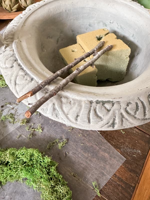 Container and gathered sticks to make a topiary.