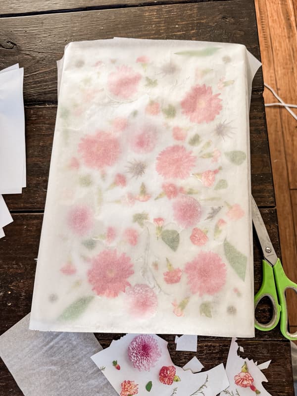 Lay parchment paper over flower print to decoupage the top of upcycled scrap lumber.