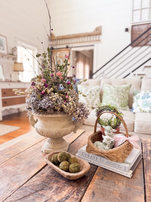 Coffee table centerpiece for Easter farmhouse decorating with rustic blue hydrangeas and decoupage lambs