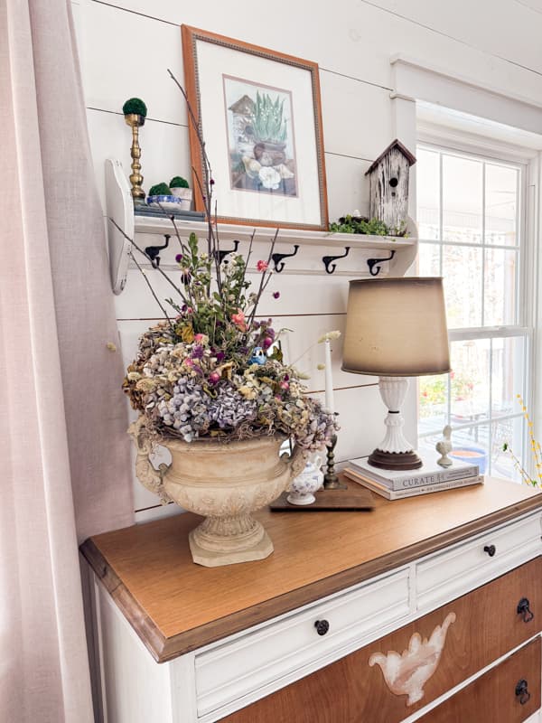 Rustic Dried flower arrangement on entry table with birdhouse and milk glass lamp for farmhouse style decor.