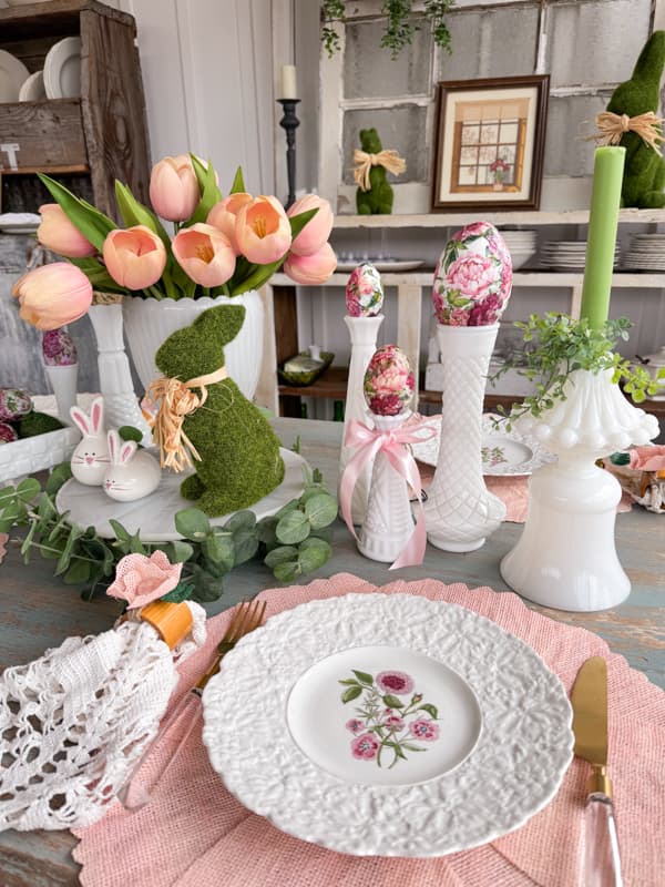 Easter Table Centerpiece Ideas with vintage milk glass and antique dishes.  Moss bunny on cake stand with pink tulips.