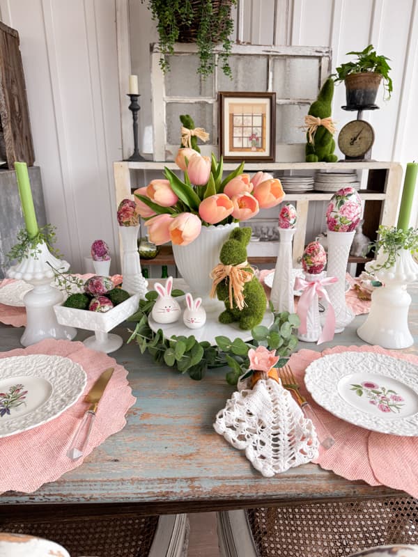 Easter Table Centerpiece Ideas with vintage milk glass and antique dishes.  Moss bunny on cake stand with pink tulips.