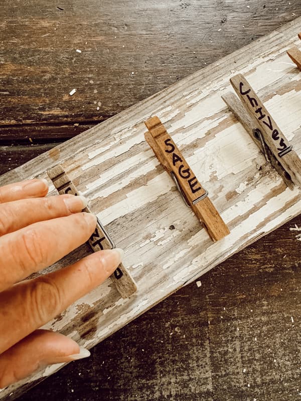 Use e6000 glue to adhere clothespins to the old wood board.  