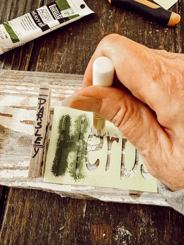 Stencil the word HERBS to the center of the DIY herb drying rack made with reclaimed wood.