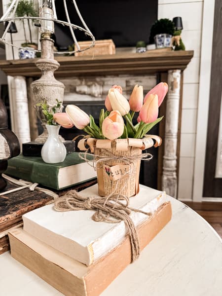 Flower Pot Decorating Ideas with pink tulips and old deconstructed books on side table 