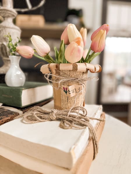 Add ribbon and tags to flower pots filled with faux tulips on old books
