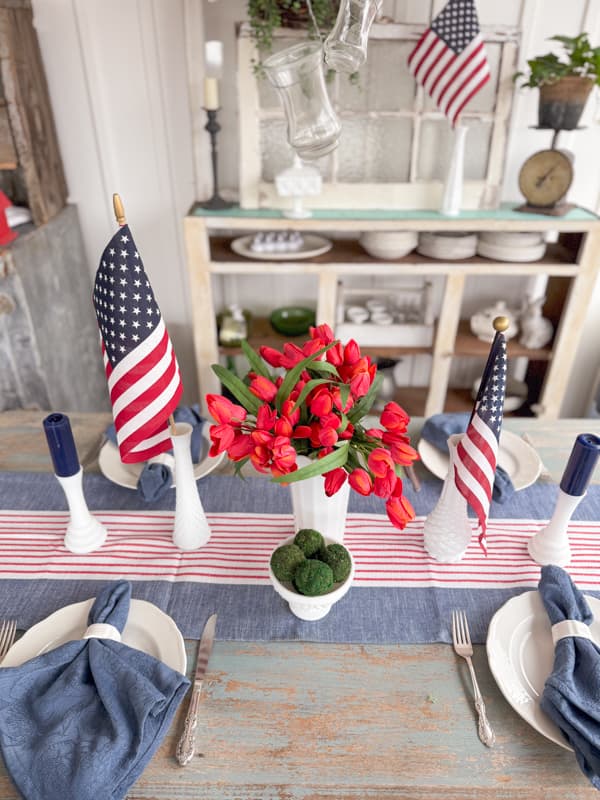 Patriotic Table setting with milk glass, flags, candles and striped table runner for Memorial Day, 4th of July & Labor day.