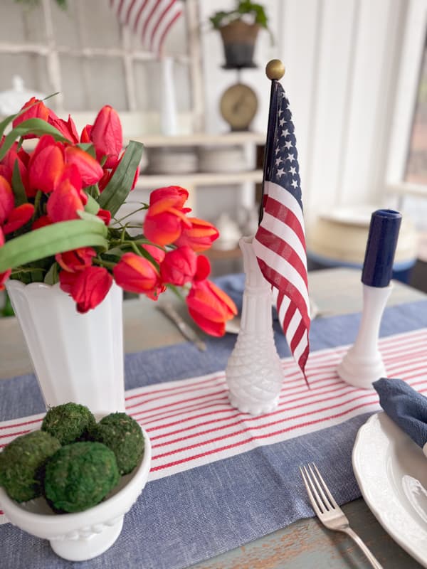 Patriotic Table setting with flags, candles and striped table runner for Memorial Day, 4th of July & Labor day.
