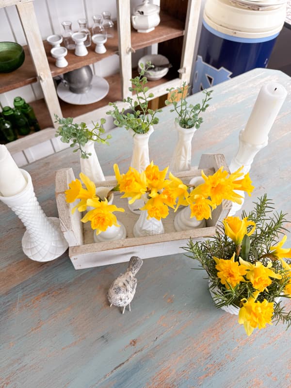 Bud vases filled with fresh daffodils in tool box with tiny bird for Spring Table Centerpiece ideas