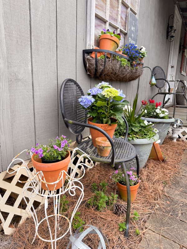 Outdoor Container Garden vignette with old chair and plant stand, window box garden and DIY Faux concrete planting containers.  