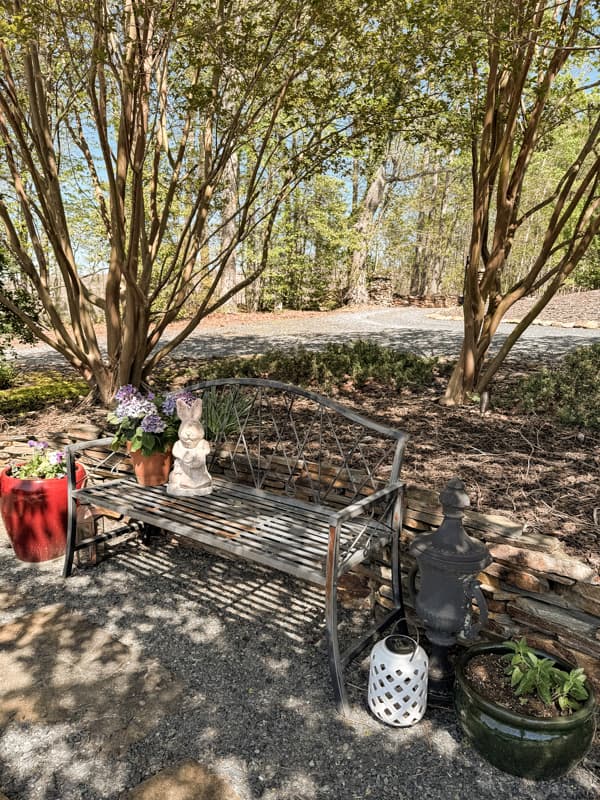 Garden decorations with bench, planters and garden statue bunny with terra cotta pot of hydrangeas.  