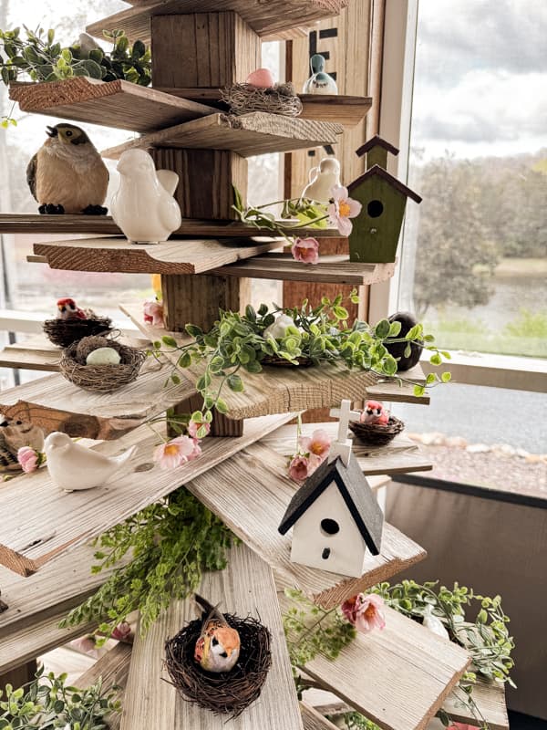 Birdhouse with birds and nests fill shiplap branches on the reclaimed DIY shiplap tree.  