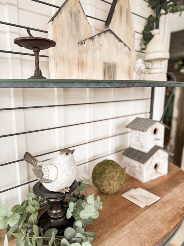 Bakers rack with spring birds and birdhouse on screen porch for spring decorating ideas.  